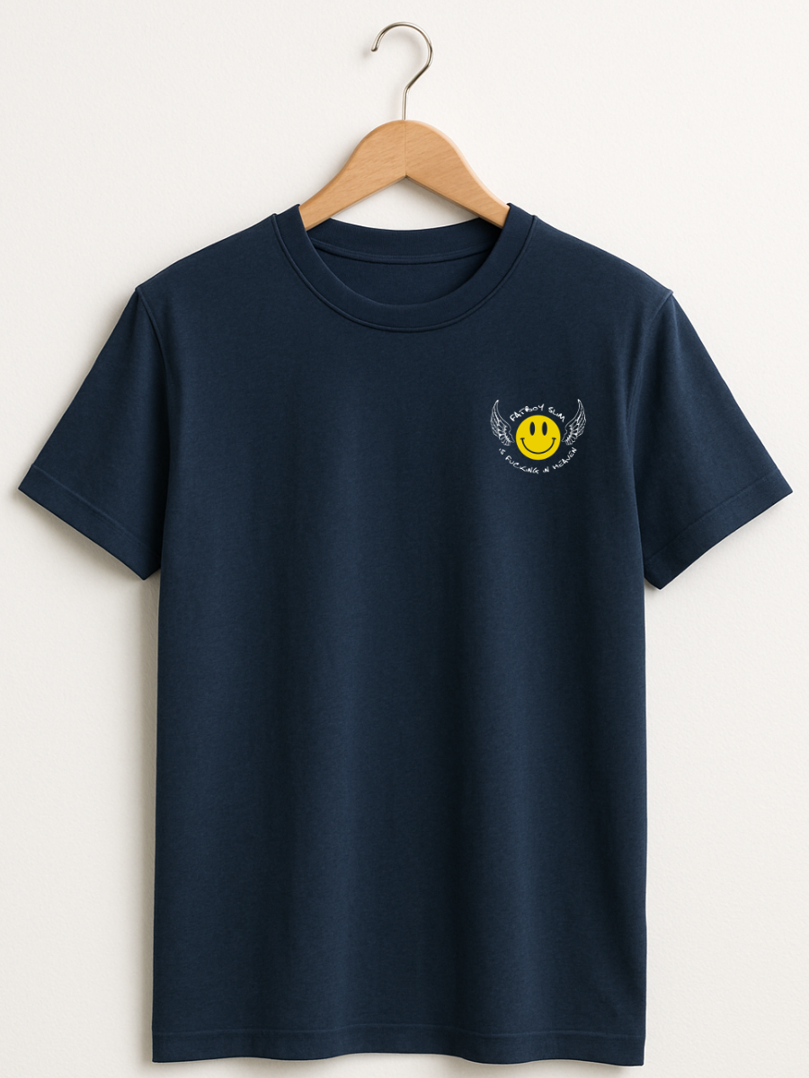 A navy blue short-sleeve crewneck t-shirt hanging on a wooden hanger against a light beige wall. The shirt features a small yellow smiley face graphic with white wings on the left chest.