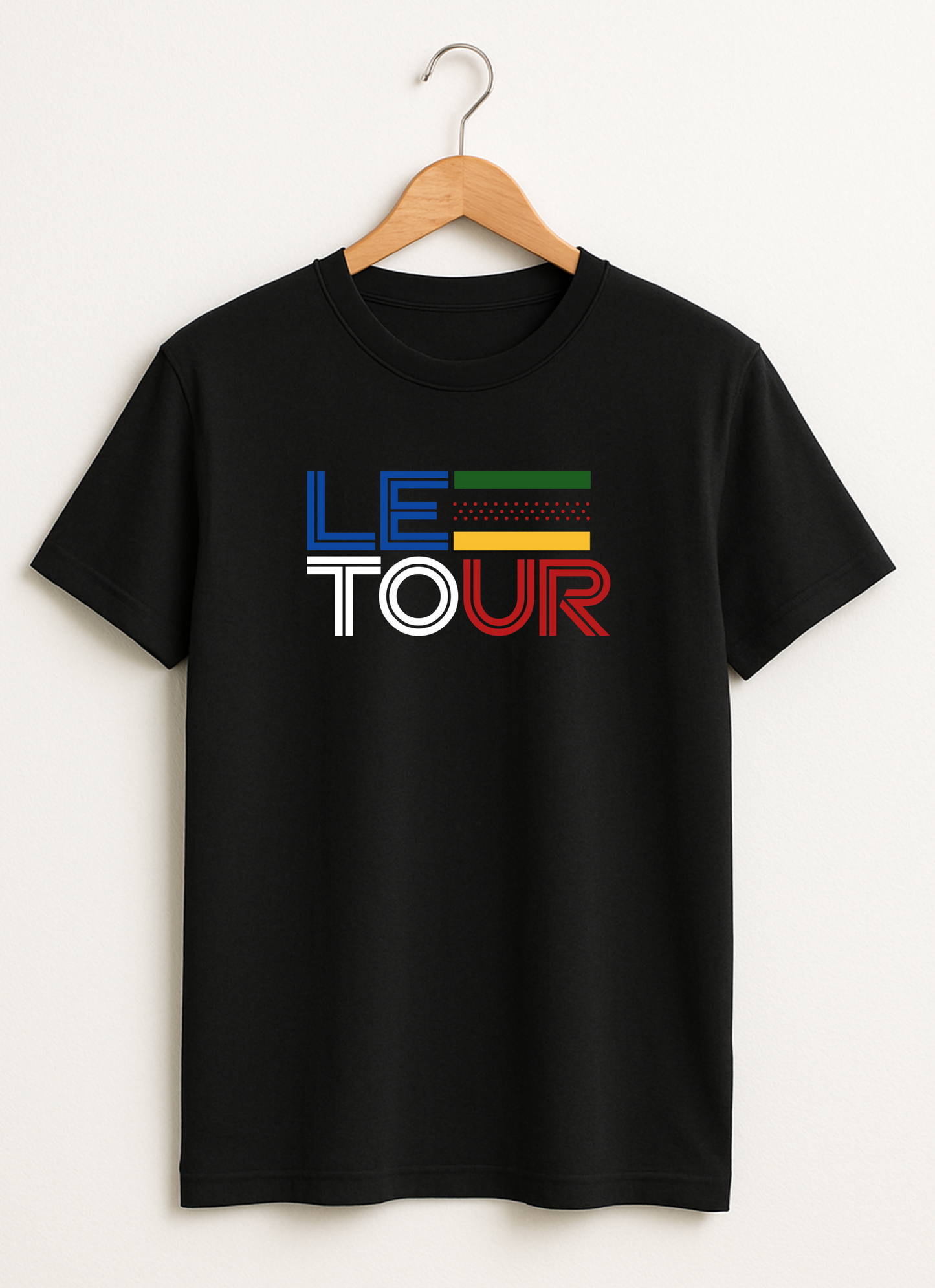 Black t-shirt with 'LE TOUR' text on a hanger against a white background