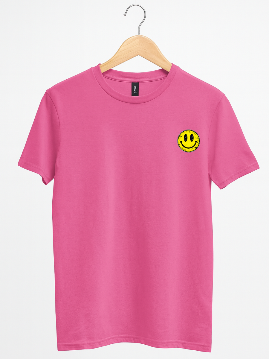 A bright pink short-sleeve crewneck t-shirt hanging on a wooden hanger against a clean white background. The shirt features a small yellow smiley face graphic printed on the left chest.
