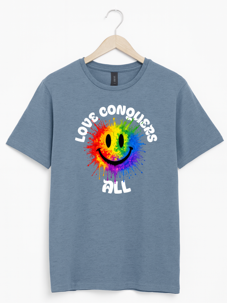A heathered blue short-sleeve t-shirt hanging on a wooden hanger against a white background. The shirt features a colorful graphic of a rainbow smiley face with the text 'LOVE CONQUERS ALL' in white arched above and below.