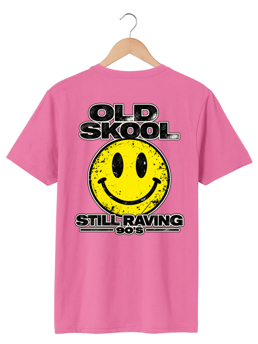 A pink short-sleeve t-shirt on a wooden hanger, featuring a distressed yellow smiley face graphic with black text reading 'OLD SKool STILL RAVING 90s' on the front.