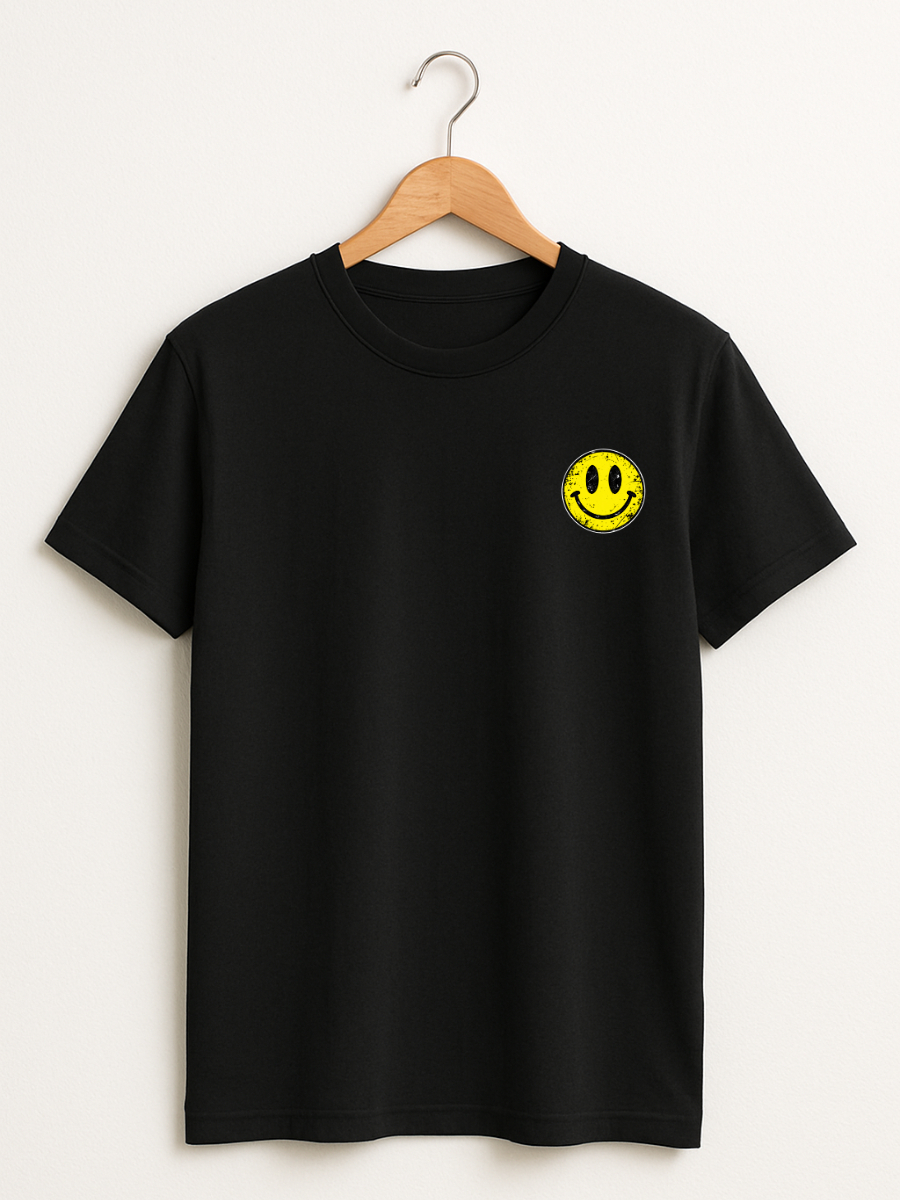 A black short-sleeve crewneck t-shirt hanging on a wooden hanger against a light beige wall. The shirt features a small yellow smiley face graphic printed on the left chest.