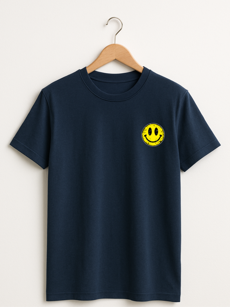 A navy blue short-sleeve crewneck t-shirt hanging on a wooden hanger against a light beige wall. The shirt features a small yellow smiley face graphic on the left chest.