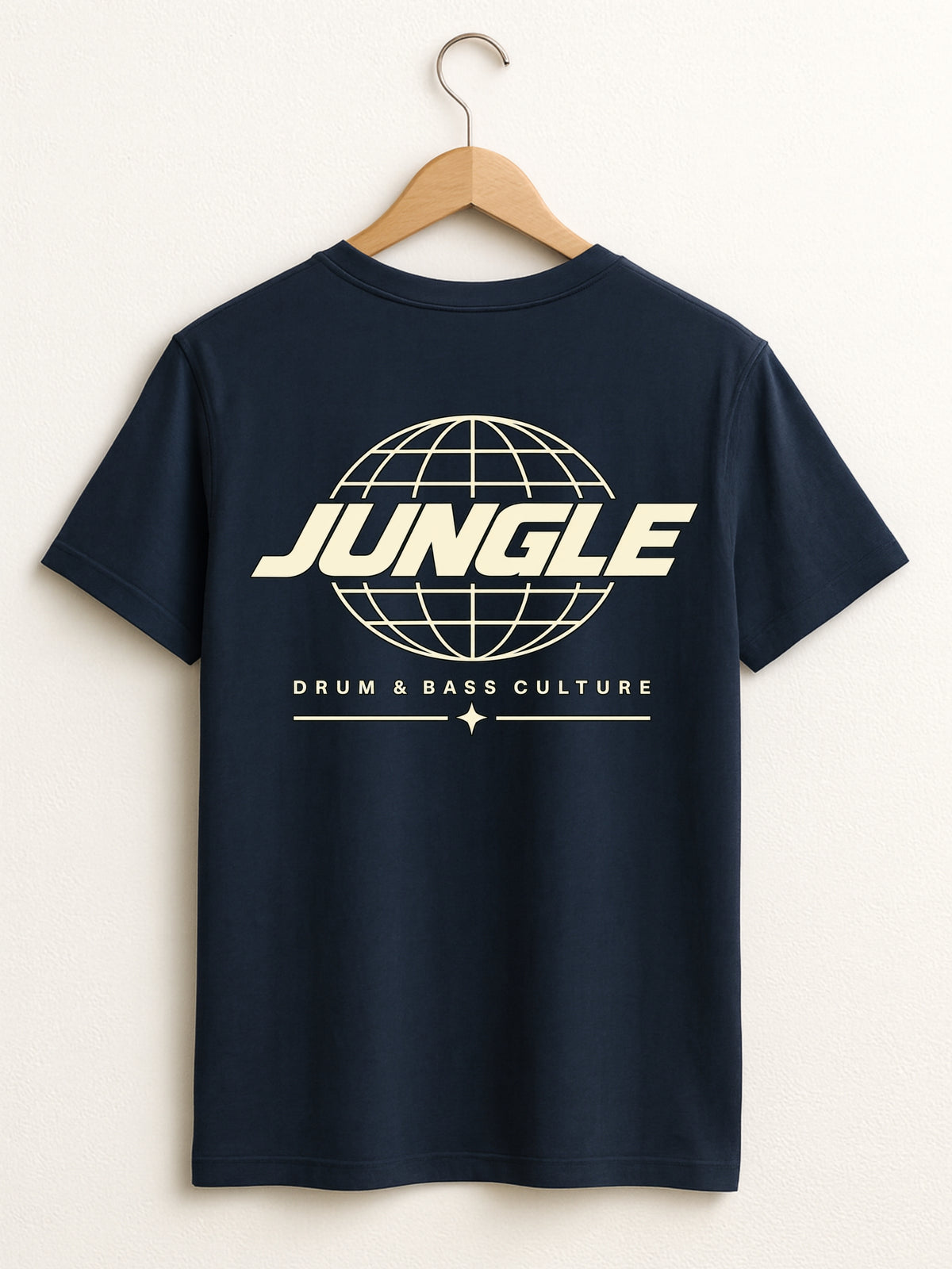 A navy blue short-sleeve t-shirt hanging on a wooden hanger against a light beige wall. The back of the shirt features a cream-colored graphic of a globe with the word 'JUNGLE' across it and the text 'DRUM & BASS CULTURE' underneath.
