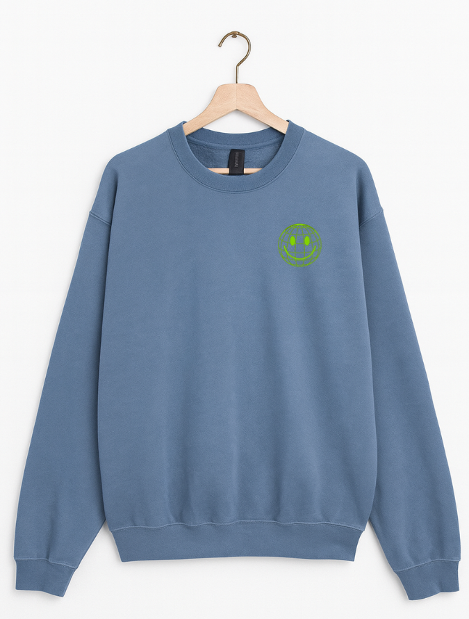 Blue sweatshirt with a green smiley face on a hanger against a white background