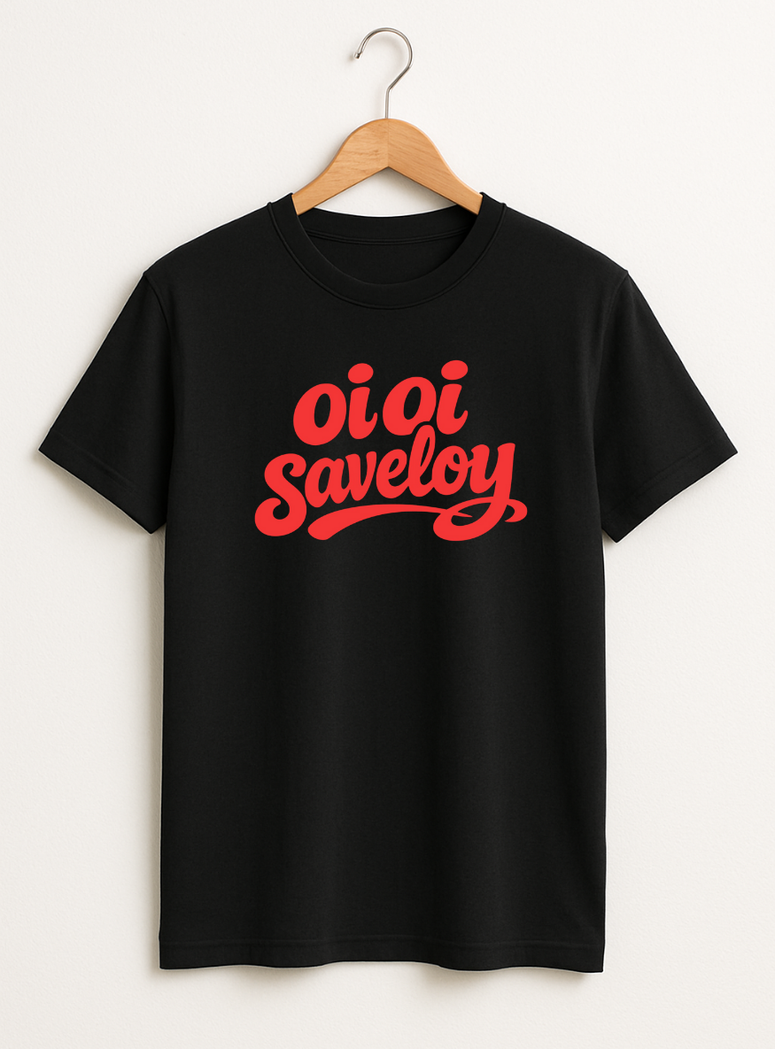 Black t-shirt on a wooden hanger featuring bold red script text reading “Oi Oi Saveloy” on the front.