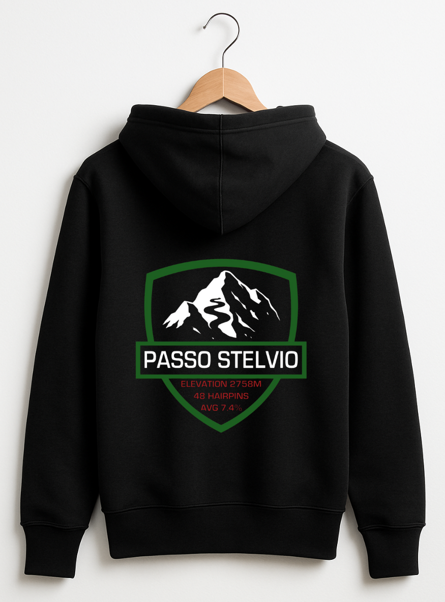 Black hoodie displayed on a wooden hanger against a teal background, featuring a bold Passo Stelvio mountain crest graphic on the back with elevation, hairpins, and average gradient details.