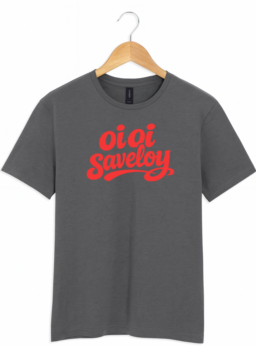 Charcoal grey t-shirt on a wooden hanger featuring bold red script text reading “Oi Oi Saveloy” on the front.