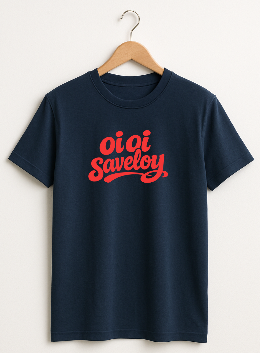 Navy t-shirt on a wooden hanger featuring bold red script text reading “Oi Oi Saveloy” on the front.