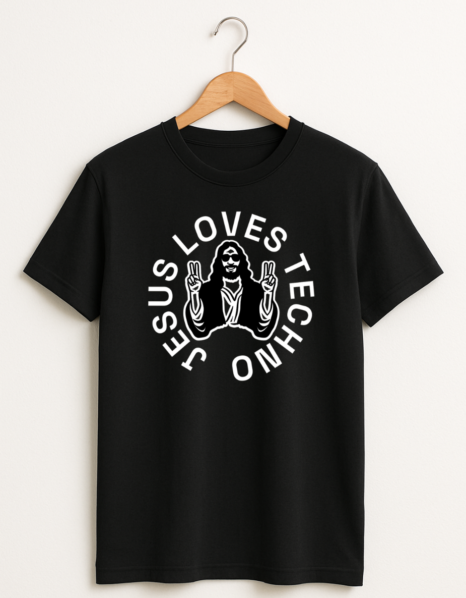 Black t-shirt on a wooden hanger featuring a white “Jesus Loves Techno” graphic with a stylized illustration of Jesus wearing sunglasses and making peace signs.