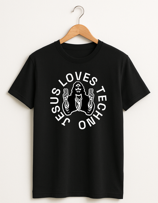 Black t-shirt on a wooden hanger featuring a white “Jesus Loves Techno” graphic with a stylized illustration of Jesus wearing sunglasses and making peace signs.