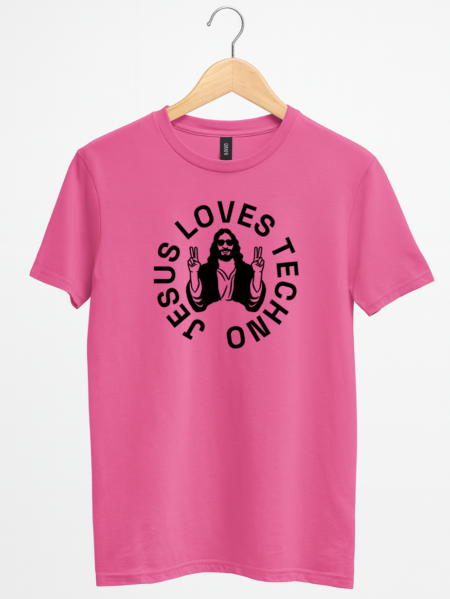 Pink  t-shirt on a wooden hanger featuring a white “Jesus Loves Techno” graphic with a stylized illustration of Jesus wearing sunglasses and making peace signs.