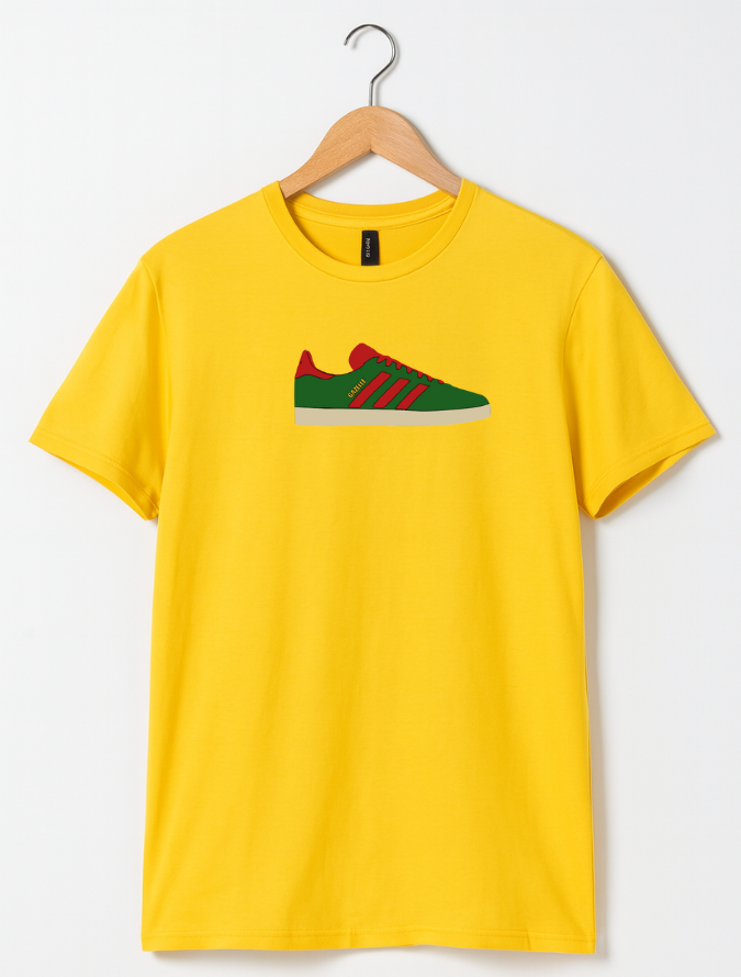 Yellow t-shirt with a graphic of green and red sneakers on a hanger against a white background