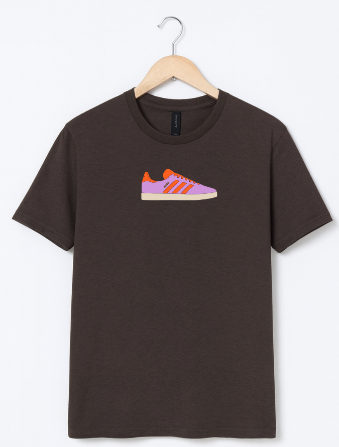 Brown t-shirt with a shoe graphic on a hanger against a white background