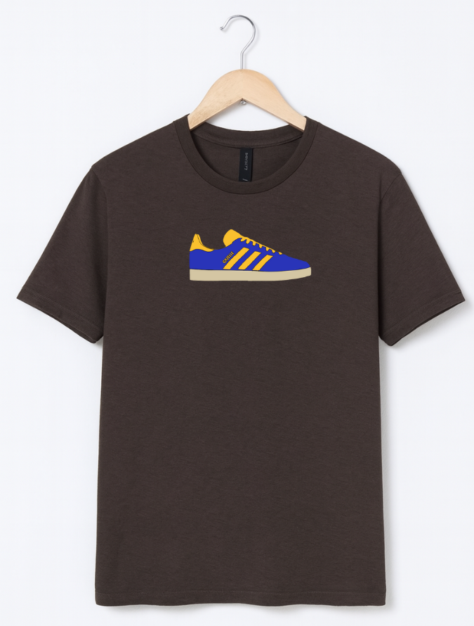 Brown t-shirt with a blue and yellow shoe graphic on a hanger against a white background