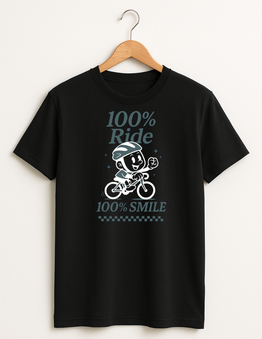 Black cycling  t-shirt with a graphic design of a character on a bike and text '100% Ride 100% Smile' hanging on a wooden hanger.